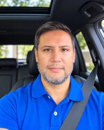 Portrait of Derwin Duarte in the driver's seat of his vehicle