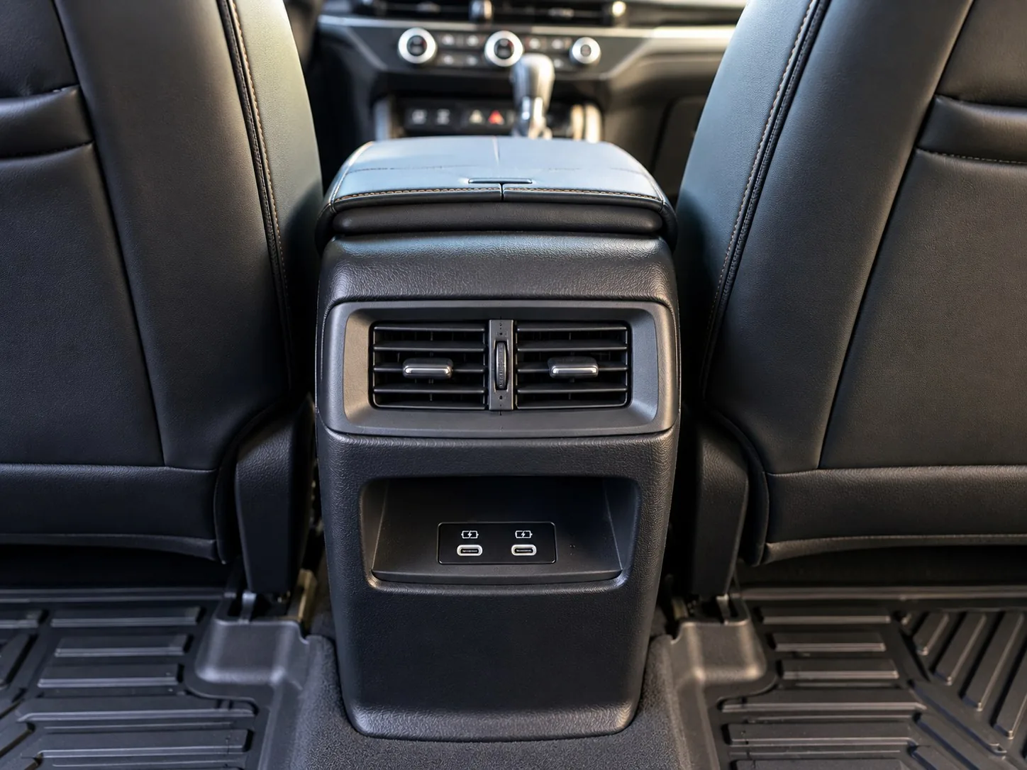 Rear air-conditioning vents and charging ports behind the front seats